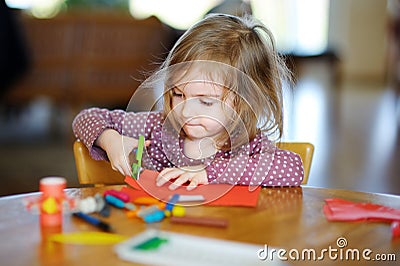 Little preschooler girl cutting paper Stock Photo