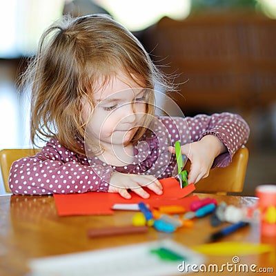 Little preschooler girl cutting paper Stock Photo