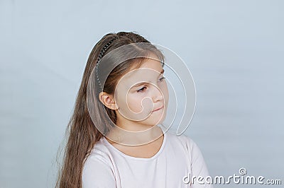 Little pretty girl with long hair, age 6-7 years old, expresses aggressive evil emotions Stock Photo