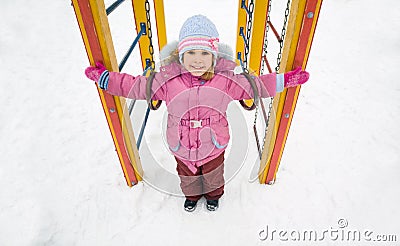 Little pretty girl on playground in winter Stock Photo