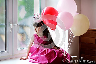 Little princess in pink dress holding baloons Stock Photo