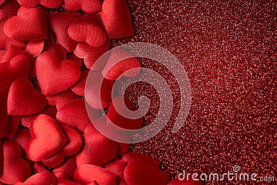 Little red satin hearts on red glitter texture, valentines or mothers day background Stock Photo