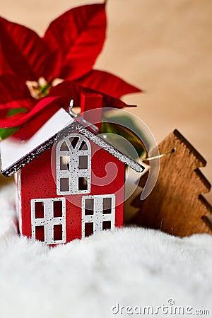 Little red toy house, wooden fir tree and poinsettia. Stock Photo