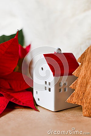Little red toy house, wooden fir tree and poinsettia. Vertical photography Stock Photo
