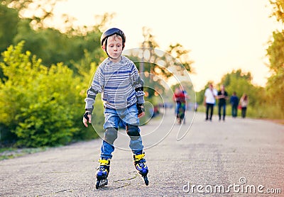 Little roller skater in the evening park Stock Photo