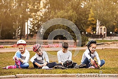 Little roller skaters sitting on grass Stock Photo