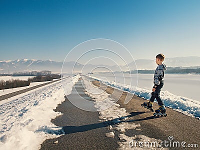 Little roller on the snowy road at the early spring Stock Photo