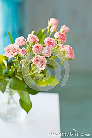 Little rose flowers on a white wooden table Stock Photo