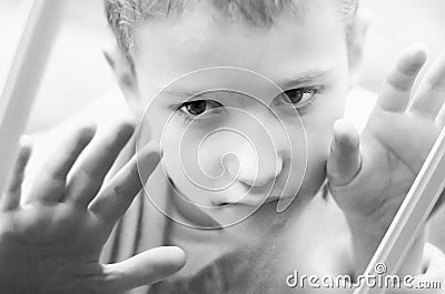 Little sad boy looks out the window. Black and white photo of a close-up child. Hungry child with big clear eyes eating bread Stock Photo