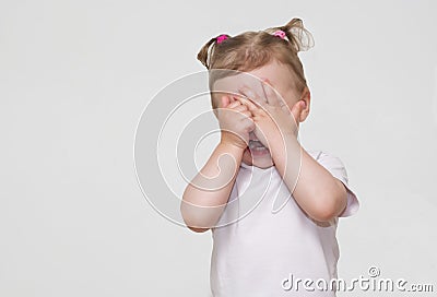 Little scared or crying or playing bo-peep girl hiding face Stock Photo