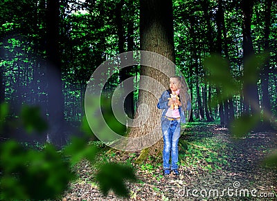 Little scared girl in the forest Stock Photo