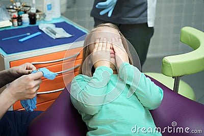 Little scared girl sitting in chair in dentist doctor office. Kid,child afraid of tooth extraction, teeth treatment Stock Photo