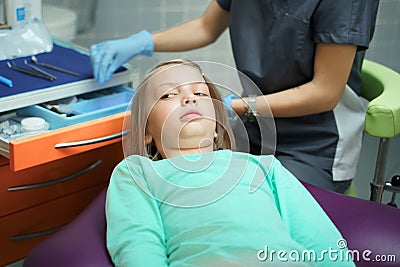 Little scared girl sitting in chair in dentist doctor office. Kid,child afraid of tooth extraction, teeth treatment Stock Photo