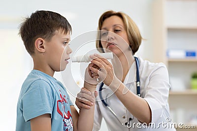 Little boy blowing to peak metr medical device. Doctor examining child`s lungs Stock Photo