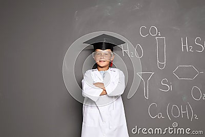 Little school child in laboratory uniform with graduate cap Stock Photo