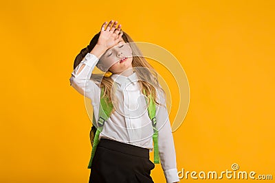 Little Schoolgirl Feeling Bad Touching Head, Yellow Background Stock Photo