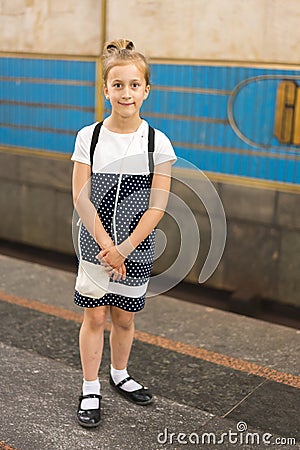 Little schoolgirl on the platform in the subway. vertical photo Stock Photo