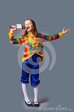 Little singer girl with microphone over grey background Stock Photo