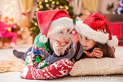 Little sister tells winter story to her brother. Children dreaming about christmas gifts Stock Photo