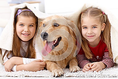 Little sisters having fun with pet dog Stock Photo