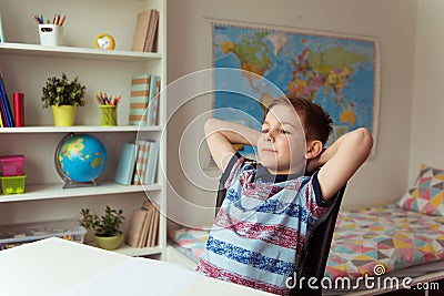 Little smart school boy making homework at desk in room Stock Photo