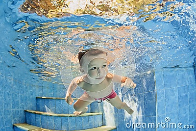 Little smiling child swimming underwater in pool Stock Photo