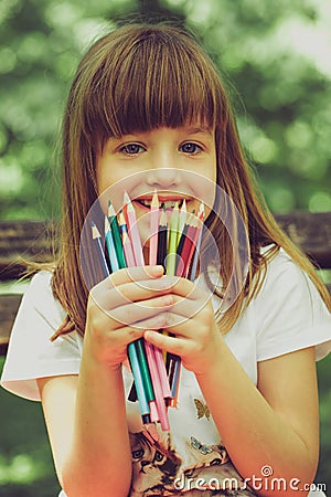 Girl is holding the crayons Stock Photo