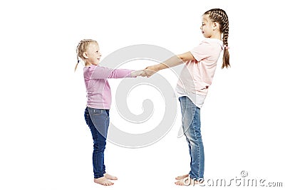 Little smiling girls with pigtails in jeans and pink sweaters hold hands. Full height. Isolated over white background Stock Photo