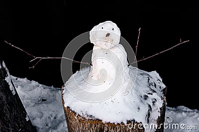 Childrens work - a little snow man with branches on a tree stump Stock Photo