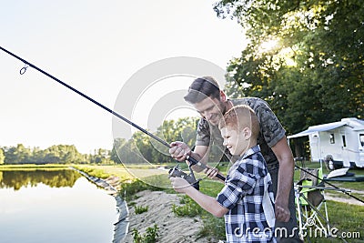 Little son taught by father how to do fishing Stock Photo