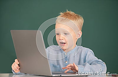 Little student boy using laptop computer in school class. Little funny programmer. Stock Photo