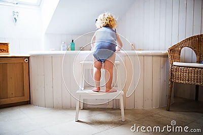Toddler boy in a dangerous situation in the bathroom. Stock Photo
