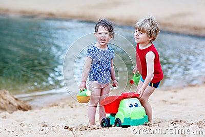 Little toddler boy and girl playing together with sand toys near Stock Photo