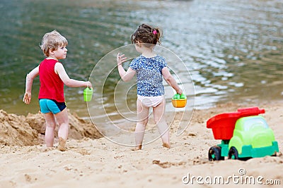 Little toddler boy and girl playing together with sand toys near Stock Photo