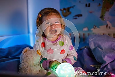 Little toddler girl crying in bed. Tired scared child after having nightmare. Afraid stressed baby not sleeping, having Stock Photo