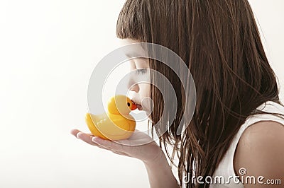 Little toddler girl kissing a yellow bath duck Stock Photo