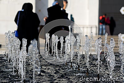 Little water fountain, in front of a blurry crowd Stock Photo