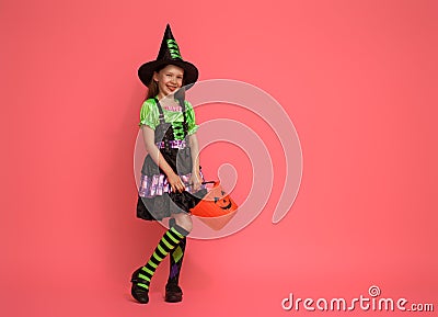 Little witch with a pumpkin on pink background Stock Photo