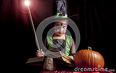 Little witch reads the Book of Spells Stock Photo