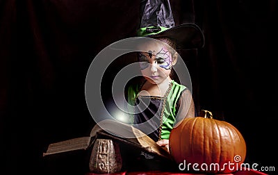 Little witch reads the Book of Spells Stock Photo