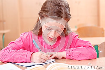 Little writing girl during classes Stock Photo