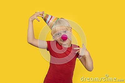 Little 5 years blond boy wearing party cap and red clown nose. birthday party Stock Photo