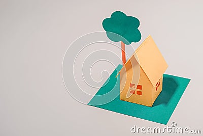 Little yellow model house under a green tree Stock Photo