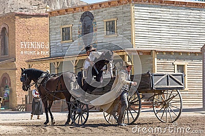 Live performance view of cowboy scenes, with 3 cowboys in wagon, on Oasys - Mini Hollywood, Spanish Western theme park, Western Editorial Stock Photo