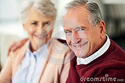 And we lived happily ever after...Portrait of a senior couple sitting together at home. Stock Photo