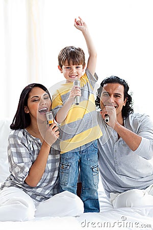 Lively young family singing with microphones Stock Photo