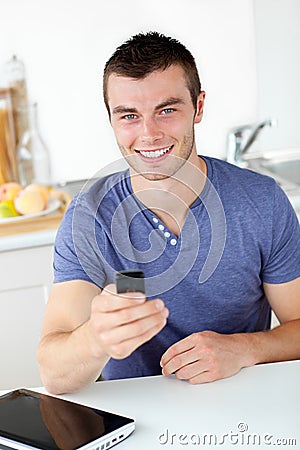 Lively young man sending a text and smiling Stock Photo