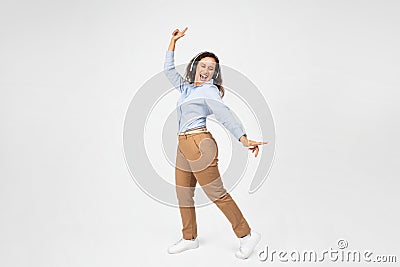 A lively young woman with curly hair, dressed in a blue shirt and brown pants Stock Photo