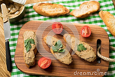 Liver pate on the bread on wooden tray. Stock Photo