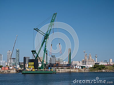 With the Liverpool waterfront behind, the 250 tonne crane Skylift 2 operating on the submersible Skyline Barge 26 Editorial Stock Photo